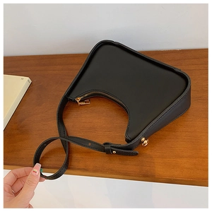 Dettaglio borsa hobo in similpelle nera con tracolla regolabile e finiture dorate