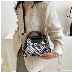 Close-up of ethnic woven pattern on small crossbody bag with round wooden handle