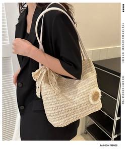 Vue détaillée du sac cabas en paille avec un nœud en dentelle et une fleur de marguerite