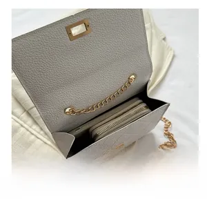 Internal view of beige quilted bag showing capacity for phone and long wallet