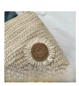 Détail d'un sac cabas tissé beige orné d'une marguerite blanche en relief 3D