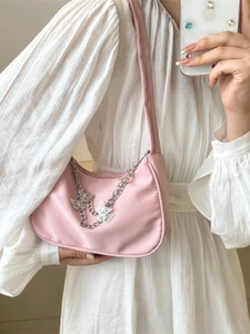 Pink nylon underarm bag for women with silver butterfly chains and a minimalist shoulder strap