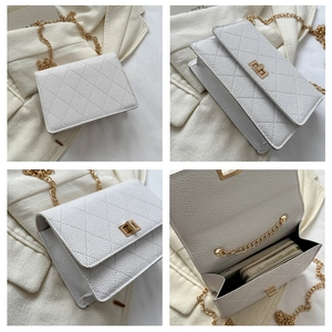 Detail view of white quilted chain bag showing interior compartments and gold metal lock