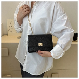 Classic black caviar leather crossbody bag with gold chain strap and turn-lock closure