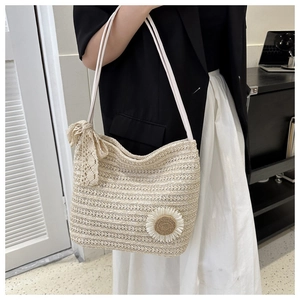 Mannequin portant un sac cabas en paille tressée beige avec fleurs et nœud en dentelle