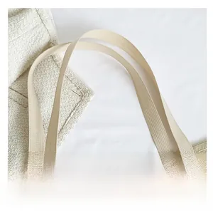 Detail of beige mesh tote bag showing durable nylon handles and breathable fabric texture