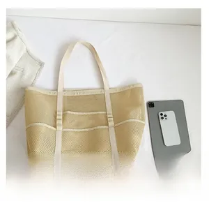 Detailed view of beige mesh tote bag showing large capacity with tablet for size reference