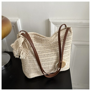 Détails du sac cabas beige en paille avec nœud en dentelle, perle tournesol et lanières