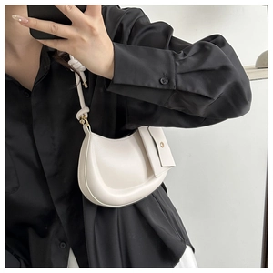 Detail of white half-moon leather shoulder bag with side pouch and knotted strap