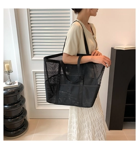 Detailed view of black mesh tote bag showing external pocket and reinforced handles