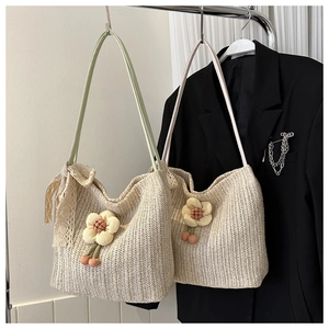 Détail du sac cabas en paille avec fleur de tournesol 3D et nœud en ruban de dentelle