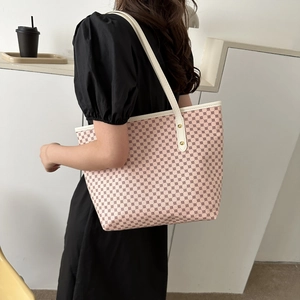 Pink polka dot tote bag with white leather handles and gold rivet accents for women