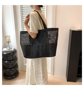 Detail of large black mesh tote bag with reinforced handles for casual daily commute