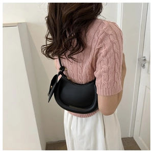 Fashionable black crescent hobo shoulder bag shown on a model in casual attire