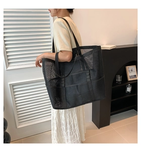 Asian model wearing a large black mesh beach tote bag with durable shoulder straps