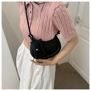 Detail of black crescent crossbody bag with a detachable small square coin purse and strap