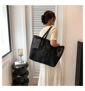 Detail of black mesh tote bag showing spacious compartments and breathable net texture