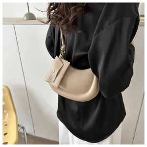 Chic beige half-moon underarm bag styled with a minimalist outfit for a modern look