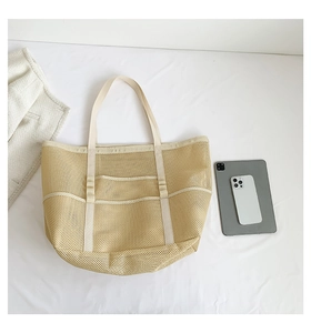 Flat lay of large mesh beach bag showing multiple outer pockets and interior storage