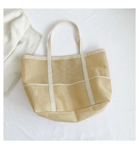 Top view of beige mesh beach tote bag with cream-colored handles and reinforced edges