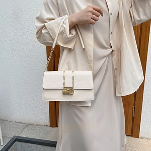 Elegante borsa a tracolla crema con trama a coccodrillo e chiusura dorata rettangolare