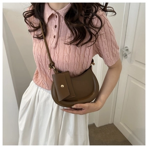 Brown saddle-style shoulder bag with adjustable strap and small detachable coin pouch