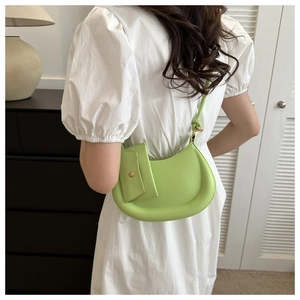 Detailed shot of lime green crescent bag with detachable coin purse on white dress
