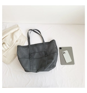 Macro view of dark grey mesh beach tote bag showing multiple pockets and storage capacity