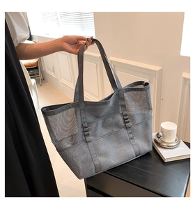 Close-up of grey mesh beach tote with reinforced straps and external storage pockets