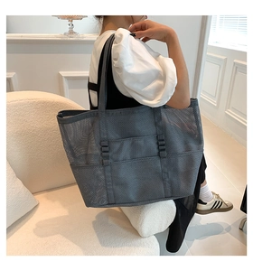 Macro detail of a grey mesh tote bag with reinforced straps and semi-transparent texture