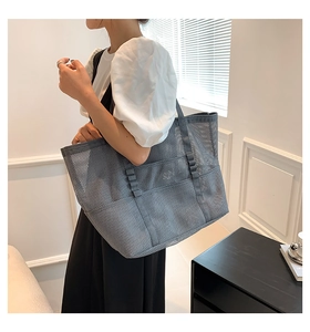 Grey mesh tote bag detail showing large capacity and breathable fabric on model