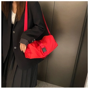 Detailed view of red waterproof gym bag with adjustable strap and buckle on model