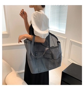 Detail of grey mesh beach tote bag featuring multiple external side pockets and reinforced handles