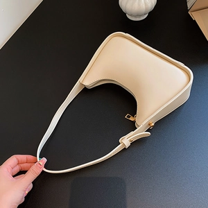 Borsa sottobraccio a mezzaluna color crema con dettagli in oro e cerniera