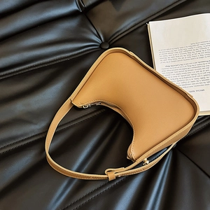 Borsa sottobraccio a mezzaluna in finta pelle caramello su sfondo trapuntato nero