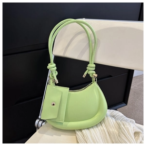 Detail of neon green half-moon shoulder bag with thin straps and small matching pouch
