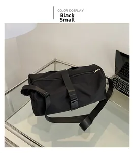 Detail view of small black waterproof sports crossbody bag on glass desk with laptop