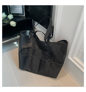 Detail of black mesh beach tote bag with three external pockets and breathable material
