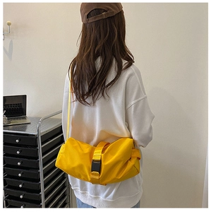 Detail view of the bright yellow waterproof cylinder bag with a secure black buckle strap