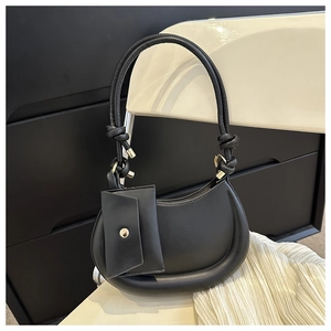 Detail of a black hobo shoulder bag with a small pouch and elegant knot handle decor