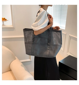 Detail of dark grey mesh beach tote with multiple exterior pockets for storage