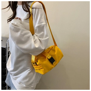 Detail of a bright yellow waterproof cylinder sports bag with adjustable wide shoulder strap