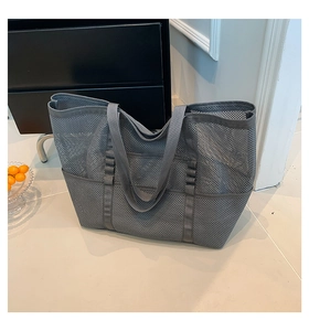 Detail view of large gray mesh beach bag with multi-pockets for organized storage
