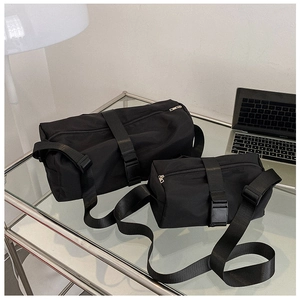 Detail of waterproof nylon duffel bags in two sizes for sports and travel set on glass table