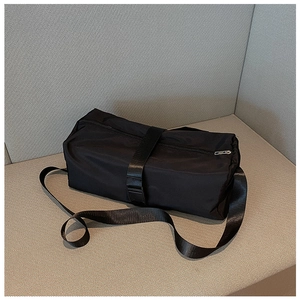 Detail of waterproof black nylon gym bag featuring buckle strap and zipper closure