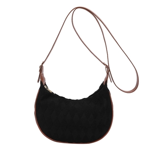Quilted black crescent underarm bag with brown leather trim and adjustable shoulder strap