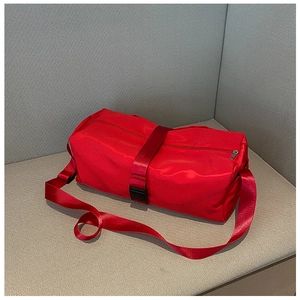 Close-up of red cylindrical gym bag with durable nylon texture and black buckle detail