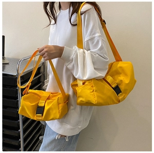 Close-up of bright yellow nylon crossbody bag set with adjustable straps and buckles