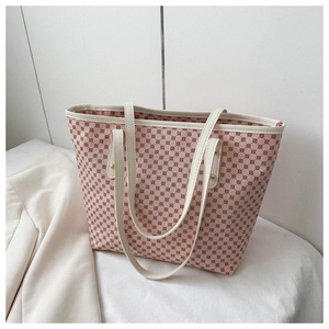 Detail of pink tote bag featuring brown geometric patterns and reinforced cream handles