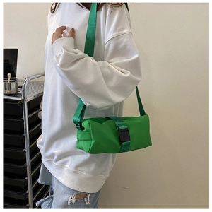 Detail of bright green nylon barrel gym bag showing the buckle and strap in a lifestyle setting